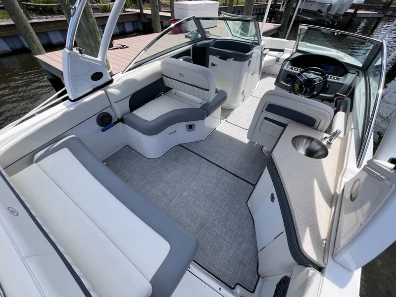 Slide: The Image of 2019 Cobalt 25 SC boat interior with seating, steering wheel, and fresh water features. - 48