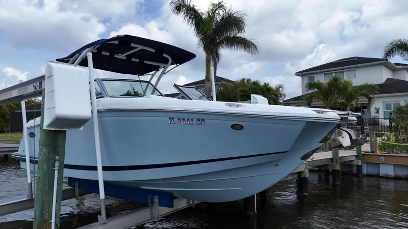 Slide: The Image of 2019 Cobalt 25 SC boat on lift, fresh water use, palm trees in background. - 5