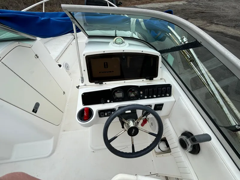 Slide: The Image of 2002 Boston Whaler 210 Ventura boat dashboard with steering wheel and navigation controls. - 6