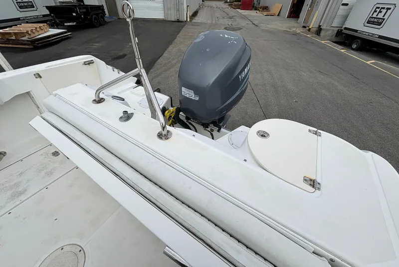 Slide: The Image of 2002 Boston Whaler 210 Ventura boat with Yamaha outboard motor, docked in an industrial area. - 9