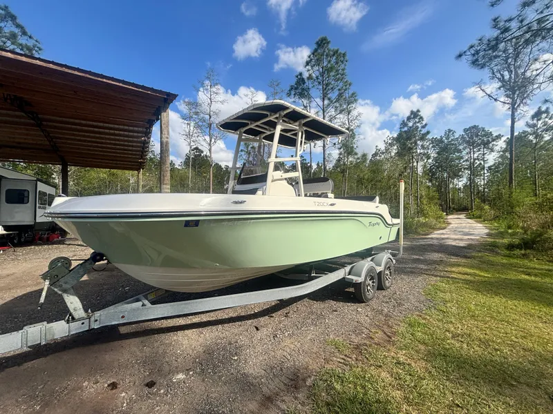 Slide: The Image of 2022 Bayliner Trophy T20CX boat on trailer, parked outdoors under a clear sky. - 1