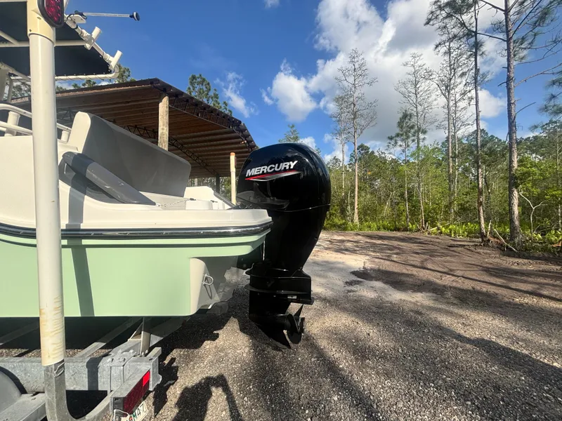 Slide: The Image of 2022 Bayliner Trophy T20CX boat with Mercury engine, parked outdoors under a clear sky. - 12