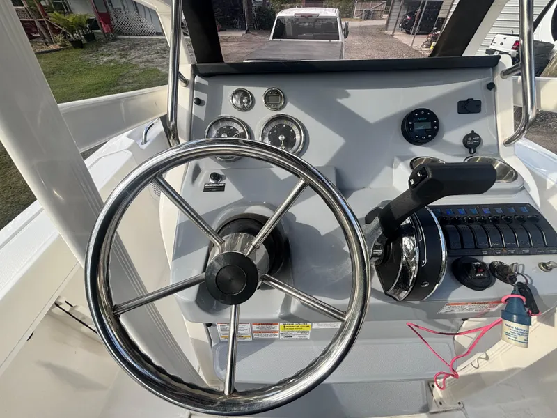 Slide: The Image of 2022 Bayliner Trophy T20CX boat dashboard with steering wheel and control panel. - 21