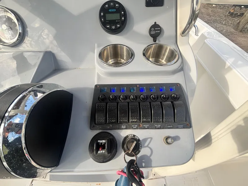Slide: The Image of Control panel of 2022 Bayliner Trophy T20CX boat with switches and cup holders. - 24