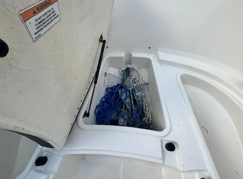 Slide: The Image of Open storage compartment on 2022 Bayliner Trophy T20CX boat with ropes and gear inside. - 27