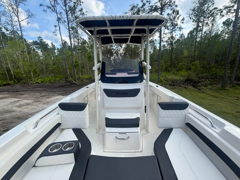 Slide: The Image of 2022 Bayliner Trophy T20CX boat with seating, cup holders, and canopy in a wooded area. - 31