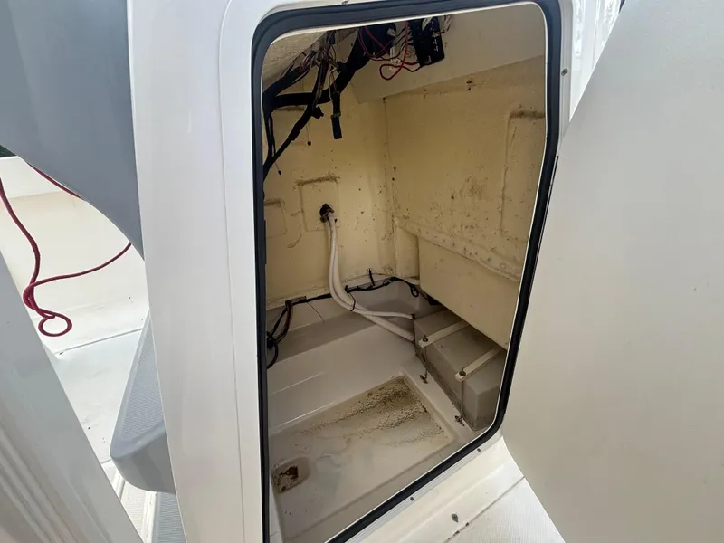 Slide: The Image of 2022 Bayliner Trophy T20CX storage compartment with visible wiring and hoses. - 35