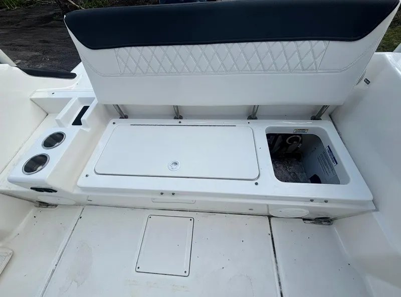 Slide: The Image of 2022 Bayliner Trophy T20CX boat seating area with storage compartment and cup holders. - 39