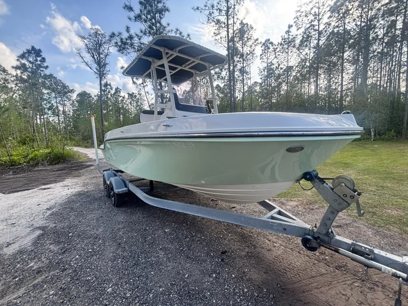 Slide: The Image of 2022 Bayliner Trophy T20CX boat on trailer in wooded area. - 6