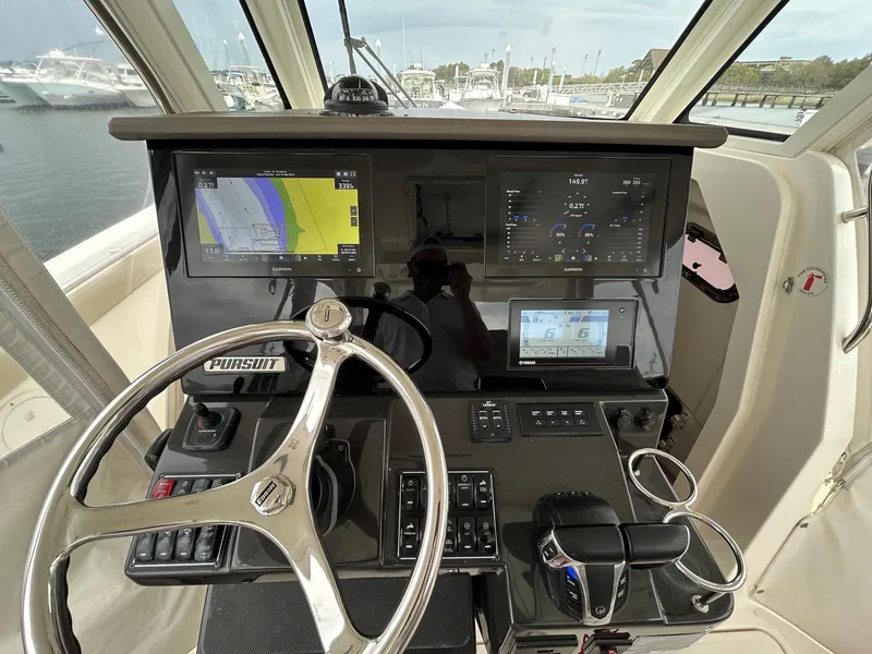 Slide: The Image of 2021 Pursuit S 328 Sport boat dashboard with navigation screens and steering wheel. - 10
