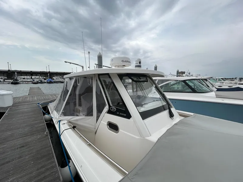 Slide: The Image of 2021 Pursuit S 328 Sport boat docked under cloudy skies. - 15