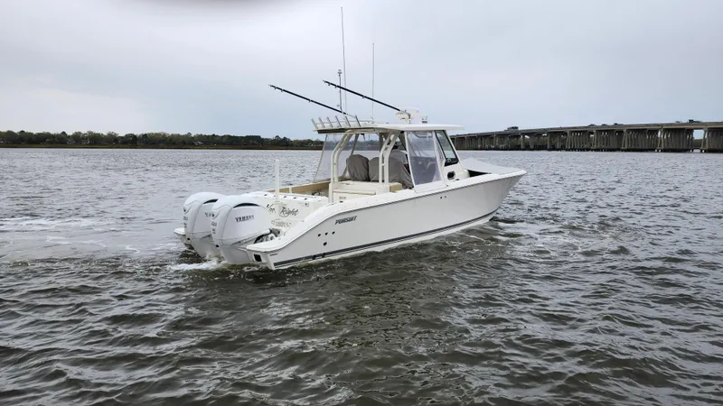 Slide: The Image of 2021 Pursuit S 328 Sport boat cruising on a calm river near a bridge. - 6