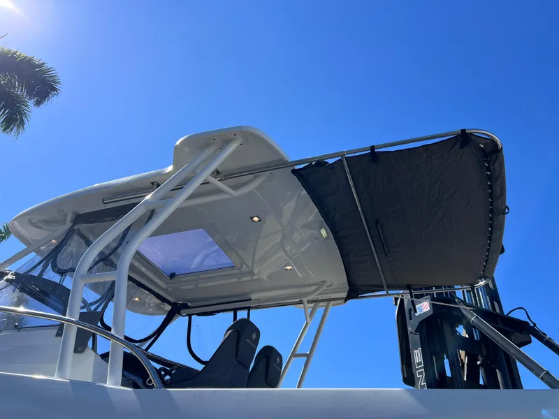Slide: The Image of 2021 Jeanneau Leader 9.0 WA boat with canopy, under clear blue sky. - 13