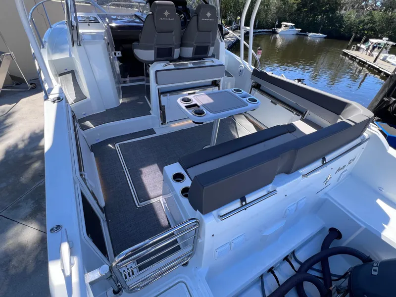 Slide: The Image of 2021 Jeanneau Leader 9.0 WA boat interior with seating, table, and water view. - 15