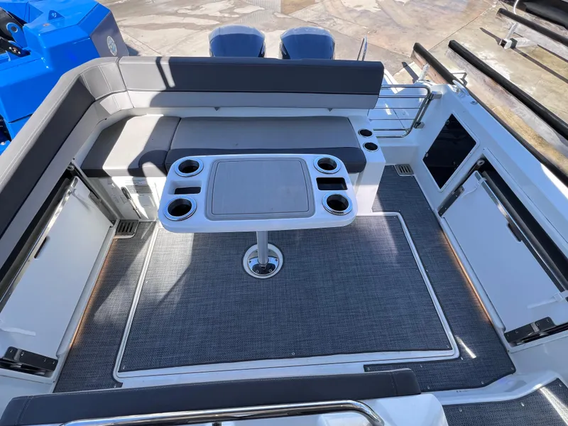 Slide: The Image of 2021 Jeanneau Leader 9.0 WA boat interior with seating and table, featuring cup holders. - 17