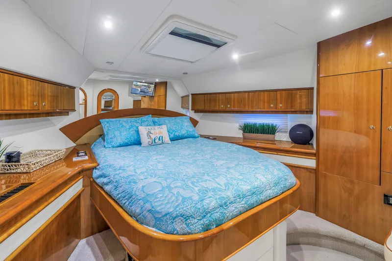 Slide: The Image of Luxurious 2007 Neptunus 62 Flybridge yacht bedroom with elegant wood finishes and blue bedding. - 11