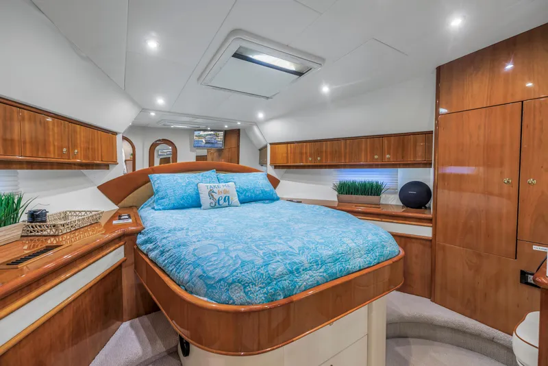 Slide: The Image of Luxurious 2007 Neptunus 62 Flybridge yacht bedroom with elegant wood finishes and blue bedding. - 16