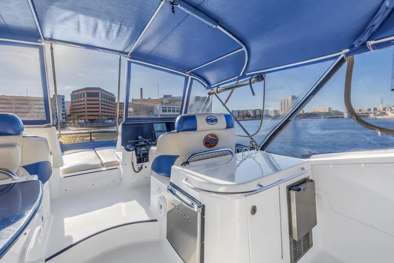 Slide: The Image of 2007 Neptunus 62 Flybridge yacht interior with blue canopy and waterfront view. - 31