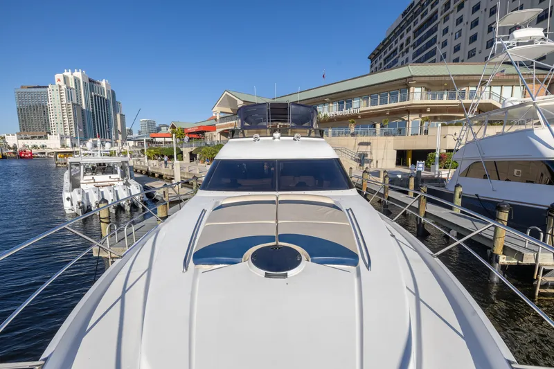 Slide: The Image of 2007 Neptunus 62 Flybridge yacht docked at a marina with cityscape background. - 47
