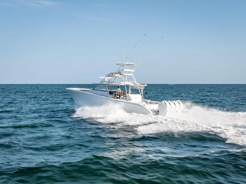 Slide: The Image of 2023 Yellowfin 54 boat cruising on open ocean under clear blue sky. - 30