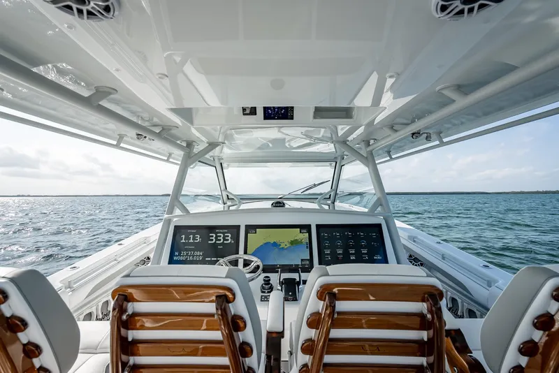 Slide: The Image of 2023 Yellowfin 54 boat cockpit with advanced navigation screens and ocean view. - 43