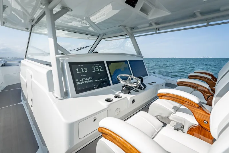 Slide: The Image of 2023 Yellowfin 54 boat cockpit with modern controls and luxurious seating on open water. - 46