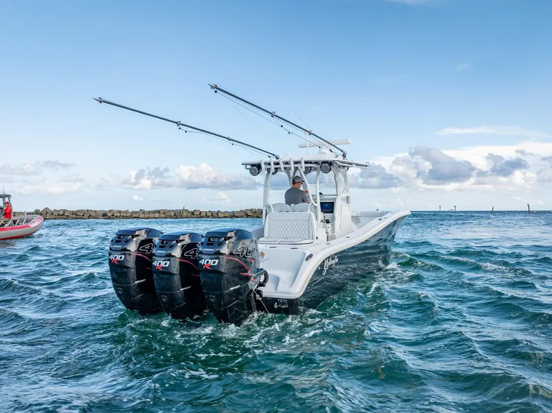 Slide: The Image of 2019 Yellowfin 34 boat with triple outboard engines cruising on open water. - 11