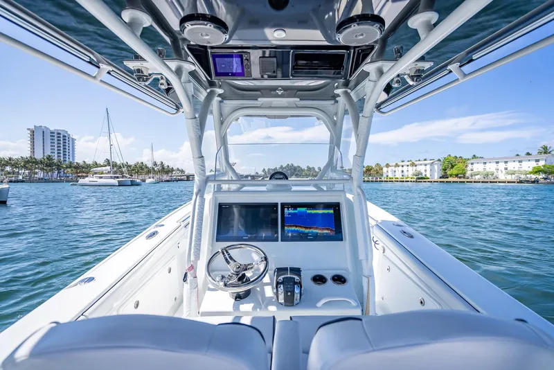 Slide: The Image of 2019 Yellowfin 34 boat cockpit with modern navigation system, steering wheel, and ocean view. - 15