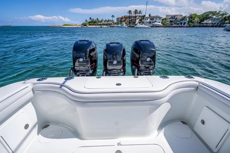 Slide: The Image of 2019 Yellowfin 34 boat with triple engines, docked near scenic waterfront homes. - 30