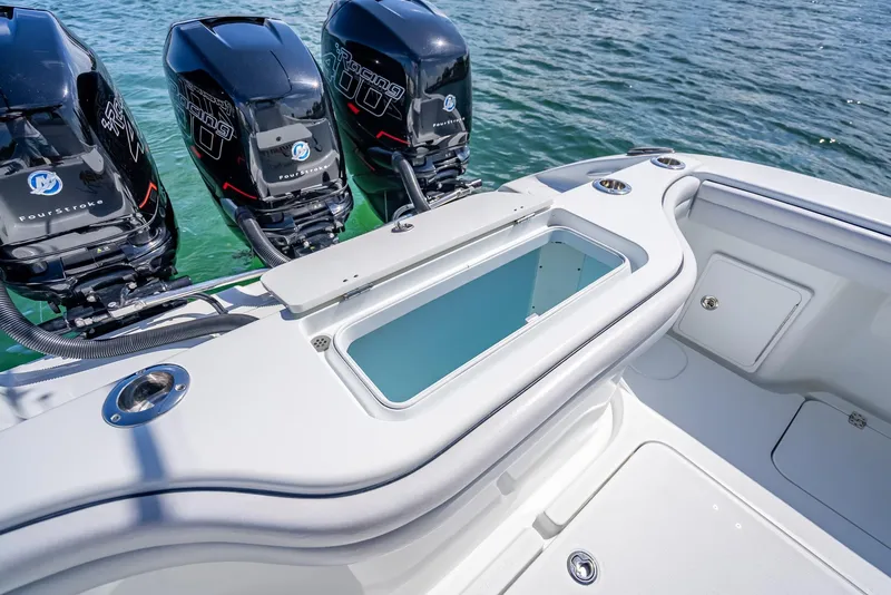 Slide: The Image of 2019 Yellowfin 34 boat with triple outboard engines and a livewell, on calm water. - 32