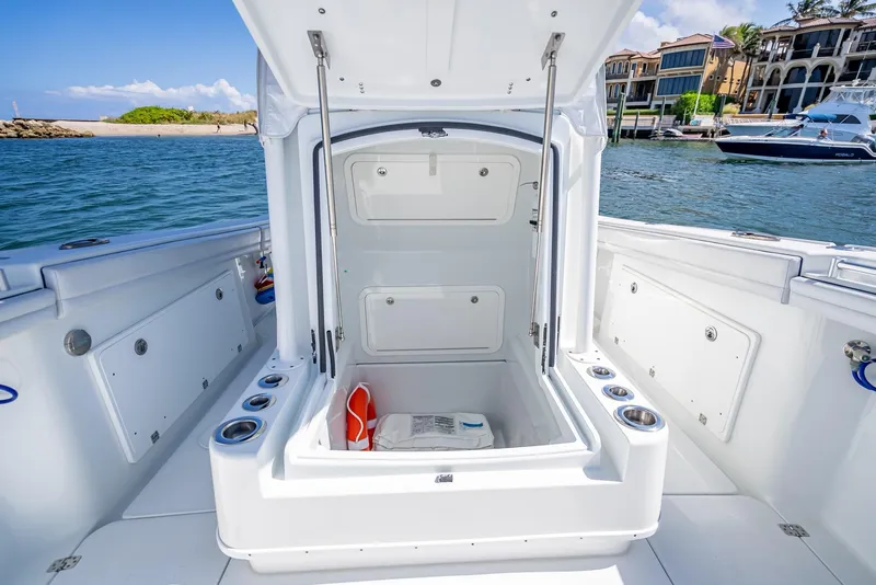 Slide: The Image of 2019 Yellowfin 34 boat with open storage compartment, docked near waterfront homes. - 41