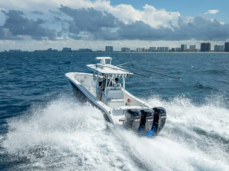 Slide: The Image of 2019 Yellowfin 34 boat cruising on ocean with city skyline in background. - 7