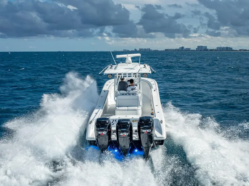 Slide: The Image of 2019 Yellowfin 34 boat cruising on ocean with powerful engines, city skyline in background. - 8