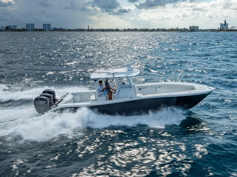 Slide: The Image of 2019 Yellowfin 34 boat cruising on open water under cloudy skies. - 9