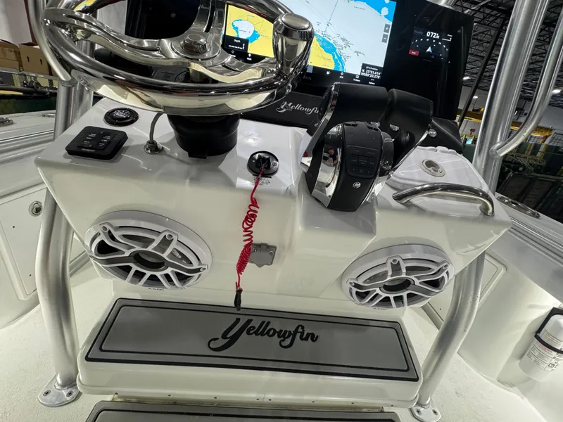 Slide: The Image of 2019 Yellowfin 26 Hybrid boat console with steering wheel, controls, and navigation display. - 10