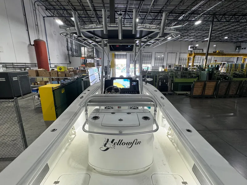 Slide: The Image of 2019 Yellowfin 26 Hybrid boat in a warehouse, showcasing its sleek design and advanced controls. - 12