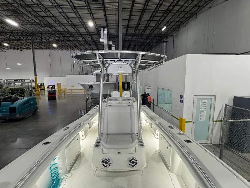 Slide: The Image of 2019 Yellowfin 26 Hybrid boat in a spacious indoor facility. - 14