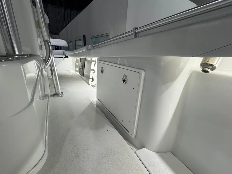 Slide: The Image of 2019 Yellowfin 26 Hybrid boat interior, showcasing sleek white design and storage compartments. - 22