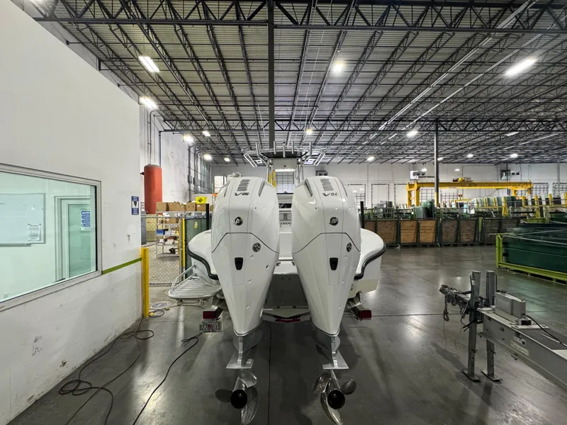 Slide: The Image of 2019 Yellowfin 26 Hybrid boat with dual engines in a spacious warehouse. - 3