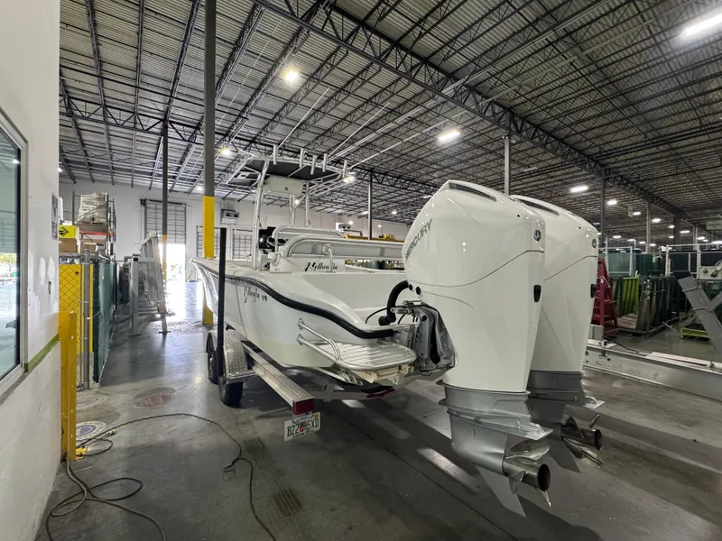 Slide: The Image of 2019 Yellowfin 26 Hybrid boat in a warehouse, featuring dual outboard engines. - 4