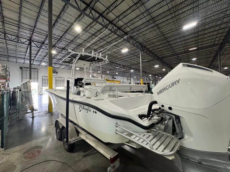 Slide: The Image of 2019 Yellowfin 26 Hybrid boat with Mercury engine in a warehouse setting. - 5