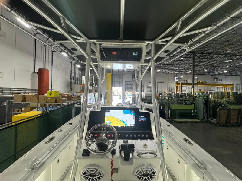 Slide: The Image of 2019 Yellowfin 26 Hybrid boat interior with navigation system in a warehouse setting. - 6