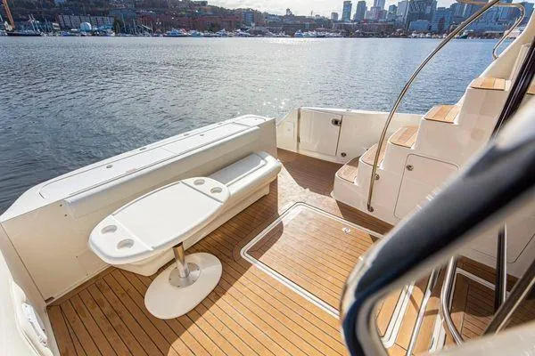 Slide: The Image of 2005 Sea Ray 520 Sedan Bridge yacht deck with seating and table, overlooking water. - 10