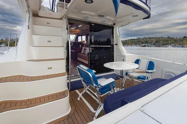 Slide: The Image of 2005 Sea Ray 520 Sedan Bridge yacht with outdoor seating and scenic water view. - 15
