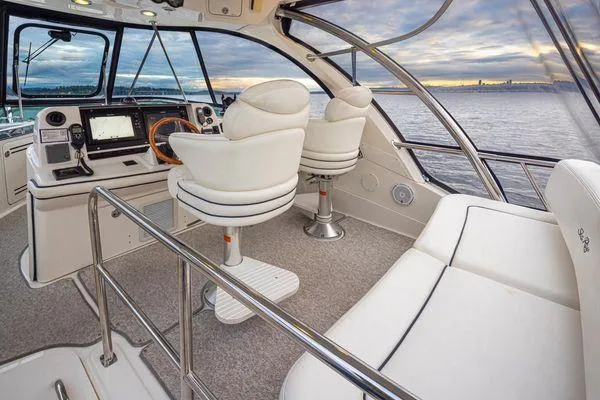 Slide: The Image of Luxurious 2005 Sea Ray 520 Sedan Bridge interior with helm and seating, overlooking serene waters. - 18