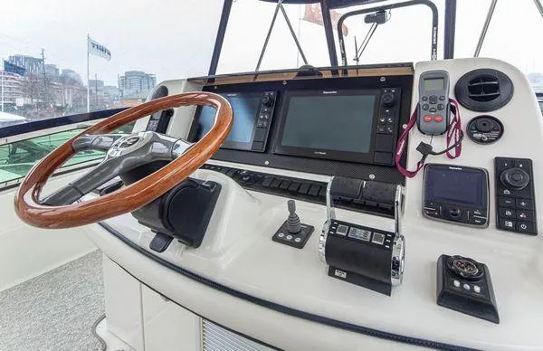 Slide: The Image of 2005 Sea Ray 520 Sedan Bridge helm with modern navigation equipment and wooden steering wheel. - 22