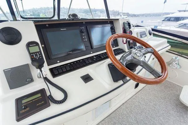 Slide: The Image of Helm of 2005 Sea Ray 520 Sedan Bridge with dual screens and wooden steering wheel. - 23