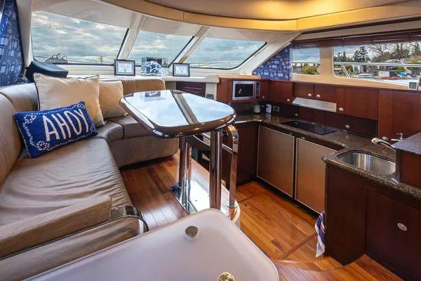 Slide: The Image of Luxurious interior of 2005 Sea Ray 520 Sedan Bridge yacht with modern kitchen and seating area. - 31