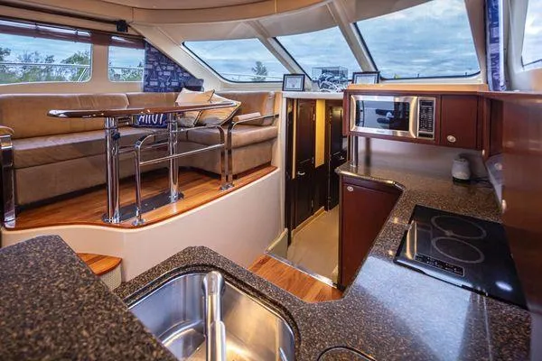 Slide: The Image of Luxurious interior of 2005 Sea Ray 520 Sedan Bridge yacht with modern kitchen and seating area. - 34
