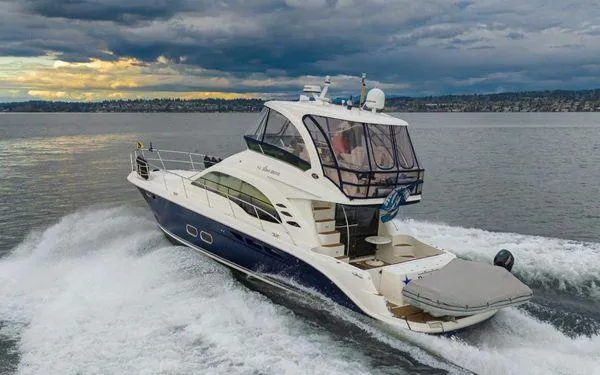 Slide: The Image of 2005 Sea Ray 520 Sedan Bridge yacht cruising on open water under cloudy skies. - 4